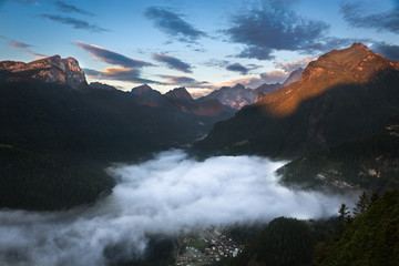Valley in Dolomites with early morning clouds, Alps, Italy