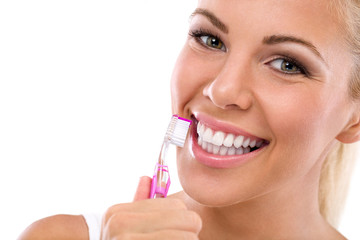 Woman brushing teeth holding toothbrush