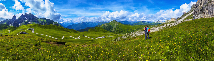 Woman on a mountain trail taking a photo, Dolomites
