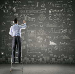 businessman drawing business plan on wall