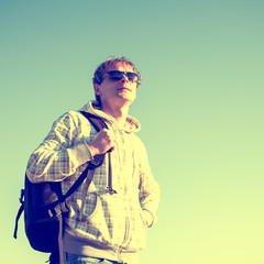 portrait of happy man hiker holding backpack