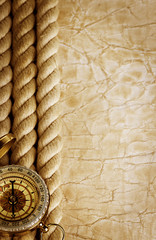 Fototapeta na wymiar Compass and rope on vintage old paper background