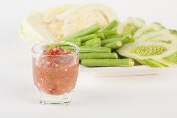 chili paste and vegetable side dishes on white paper background