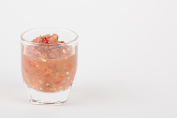 chili paste in glass on white paper background