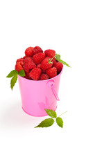 Raspberries in a small pink metal bucket. Selective focus.