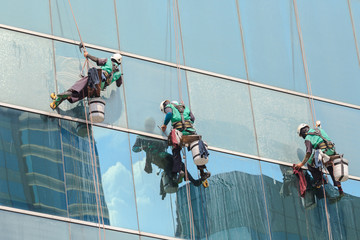 group of workers cleaning windows service on high rise building
