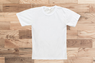 White blank T-shirt on wood texture background