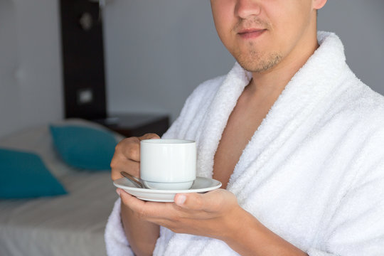 Man In Bathrobe With Cup Of Coffee In Hotel Room