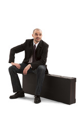 Businessman sitting on briefcase