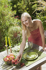Österreich, Frau, Obstschale auf dem Tisch im Garten