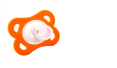 Orange colored pacifier over white background 