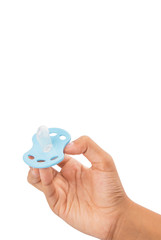 Female hand holding blue pacifier over white background