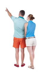 young couple in short pointing at wal