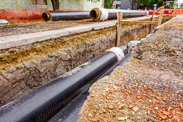 Newly laid pipe in a fresh trench. Unfinished pipeline