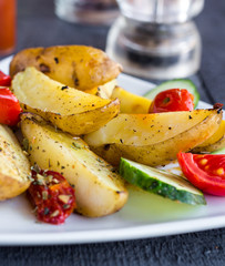 baked potato and raw vegetables on a white plate