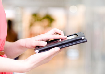 close up hands using tablet computer in shopping mall