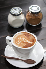 Cup of latte art on wooden table