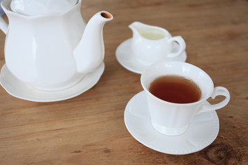 Cup of tea and tea's jar on old wooden