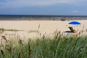Fototapeta na wymiar Blue umbrella on the beach in summer