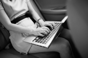 businesswoman with document and laptop in car