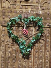 Old wooden doors with heart made from green leafs