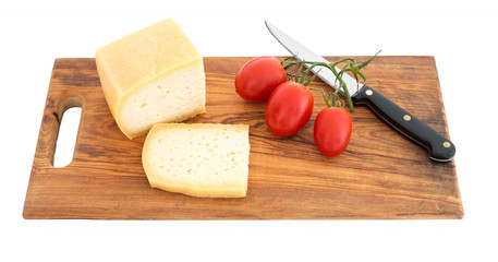 Sliced cheese on wooden board wth knife, isolated on white.