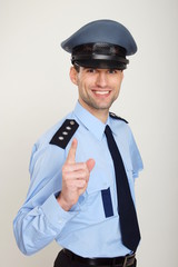 Smiling policeman shows with his finger on you