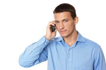 Young man in blue shirt talks into the mobile phone