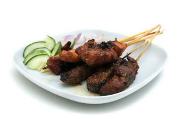 Delicious satay with cucumbers and onions served on white plate