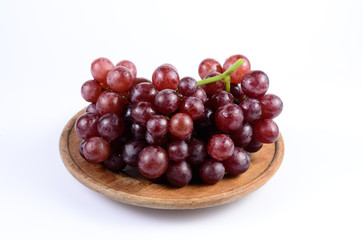 Red grape on wooden dish