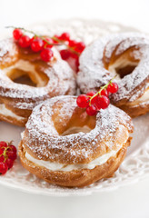 Cream puff rings decorated with fresh red currant