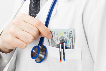 Doctor putting money into his pocket - closeup studio shot