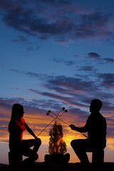 Fototapeta na wymiar silhouette man and woman hold up marshmallows