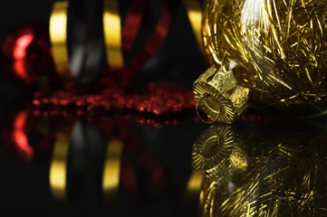 Golden and red xmas baubles on black background