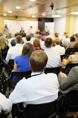 The audience listens to the acting in a conference hall