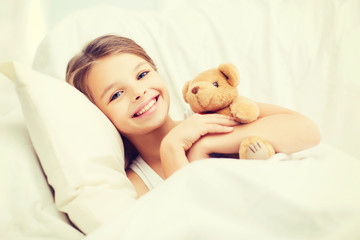 little girl with teddy bear sleeping at home