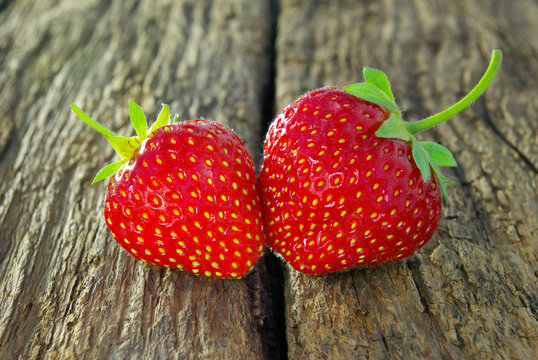 Ripe red strawberry on a wooden background