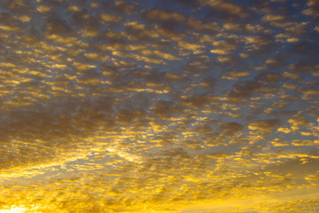 Golden rays of sunset, among the clouds in the sky