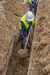 Group of workers with shovels in a trench 2