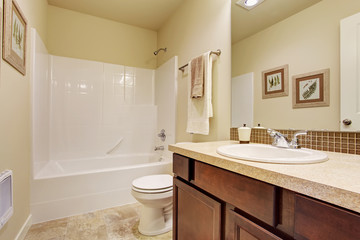 Naklejka na ściany i meble Empty bathroom in soft ivory color with tile wall trim