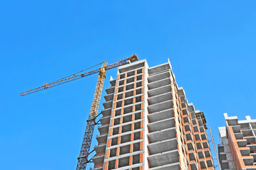 Fototapeta premium Crane and building construction site against blue sky