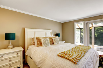 Beautiful white bed with light tone bedding and orange details