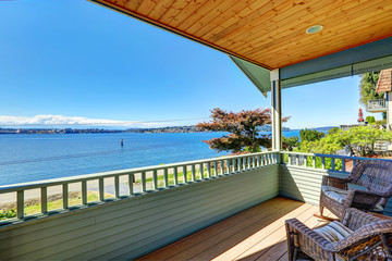Walkout deck with wicker chairs overlooking bay. Port Orchard, W