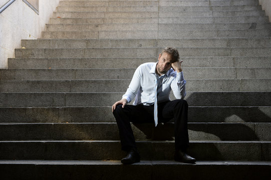 businessman sad in depression sitting on street stairs