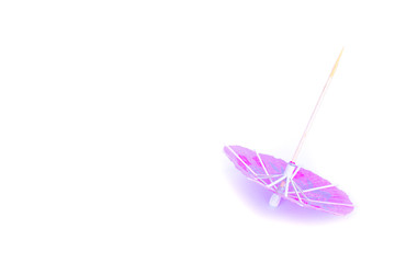 Pink cocktail umbrella on white background