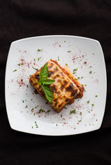 Lasagna on a square white plate