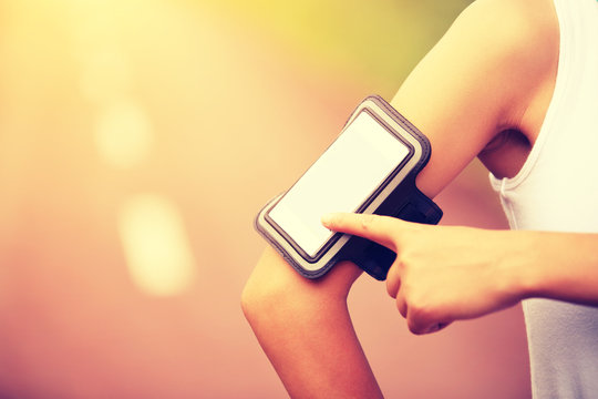 woman runner listening to music from smart phone mp3 player 