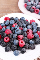 Iced berries on plates, on wooden background