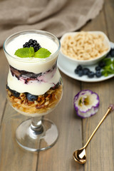 Natural yogurt with fresh berries on wooden table