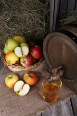 Still life with tasty apple cider in barrel and fresh apples